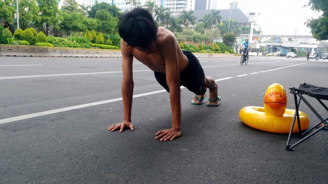 Warga berfoto di Jalan MH Thamrin yang tampak sepi saat hari ketiga lebaran, Jumat (7/6). [Suara.com/Oke Atmaja]