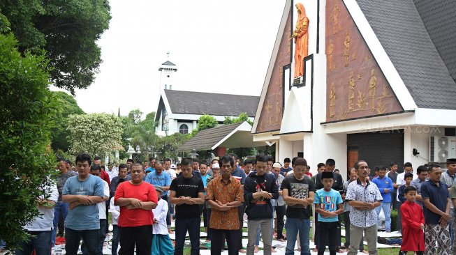 Umat muslim melaksanakan Salat Jumat berjamaah di halaman Gereja Katolik Santa Catharina di kawasan Taman Mini Indonesia Indah (TMII), Jakarta, Jumat (7/6). [Suara.com/Arief Hermawan P]