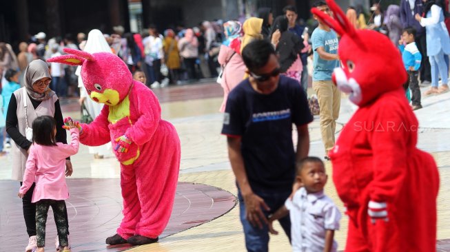 Pengunjung menikmati suasana di kawasan wisata Taman Mini Indonesia Indah (TMII), Jakarta, Jumat (7/6). [Suara.com/Arief Hermawan P]
