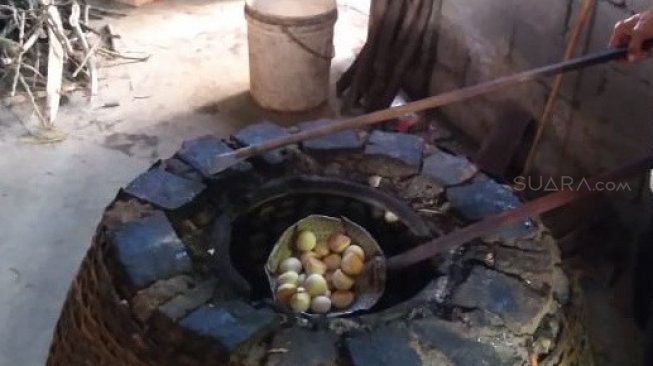 Proses pembuatan nopia menggunakan oven dari tanah liat berbentuk menyerupai kubah. [Suara.com/Teguh Lumbiria].