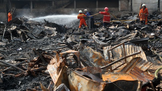 Petugas pemadam kebakaran (damkar) memadamkan sisa bara api usai terjadi kebakaran yang menghanguskan lapak pemulung di dekat Terminal Pasar Minggu, Jakarta, Sabtu (8/6). [Suara.com/Arief Hermawan P]