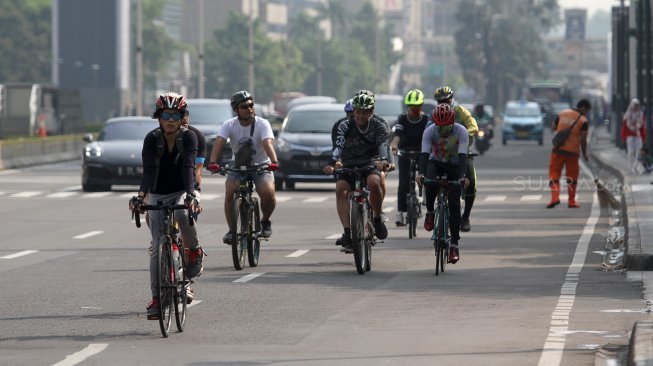 Warga berolahraga di Jalan Jenderal Sudirman, Jakarta, Minggu (9/6). [Suara.com/Arief Hermawan P]