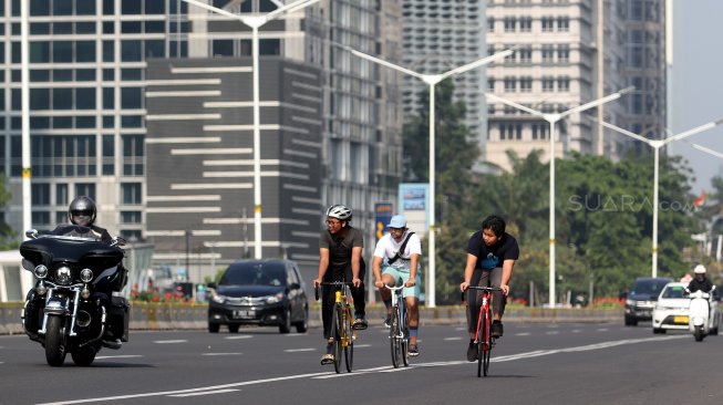 Warga berolahraga di Jalan Jenderal Sudirman, Jakarta, Minggu (9/6). [Suara.com/Arief Hermawan P]