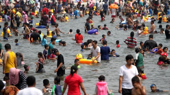 Pengunjung memadati Pantai Karnaval Ancol, Jakarta, Minggu (9/6). [Suara.com/Arief Hermawan P]
