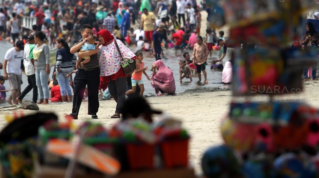 Pengunjung memadati Pantai Karnaval Ancol, Jakarta, Minggu (9/6). [Suara.com/Arief Hermawan P]
