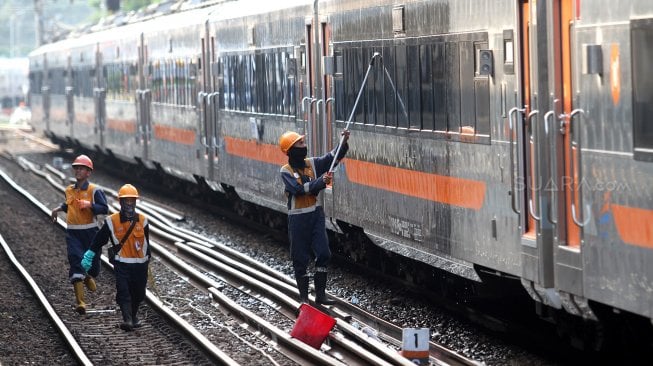 Petugas membersihkan gerbong Kereta Api di Stasiun Pasar Senen, Jakarta, Minggu (9/6). [Suara.com/Arief Hermawan P]