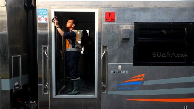 Petugas membersihkan gerbong Kereta Api di Stasiun Pasar Senen, Jakarta, Minggu (9/6). [Suara.com/Arief Hermawan P]