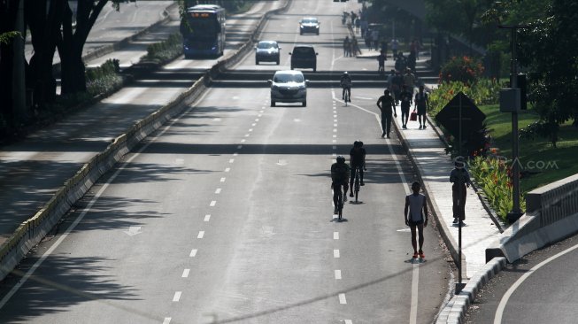 Warga berolahraga di Jalan Jenderal Sudirman, Jakarta, Minggu (9/6). [Suara.com/Arief Hermawan P]