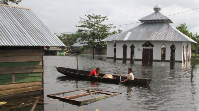 Warga berada di atas perahu menerobos banjir sejak dua pekan lalu di Desa Laloika, Kecamatan Pondidaha, Konawe, Sulawesi Tenggara, Minggu (9/6). [ANTARA FOTO/Jojon]