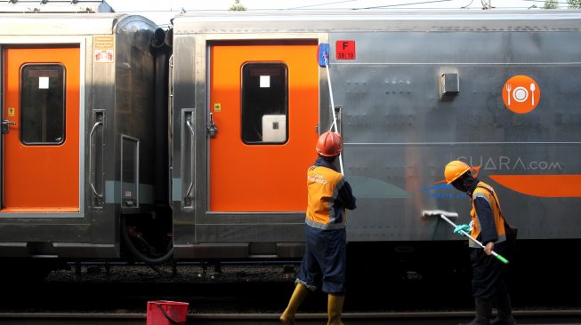 Petugas membersihkan gerbong Kereta Api di Stasiun Pasar Senen, Jakarta, Minggu (9/6). [Suara.com/Arief Hermawan P]