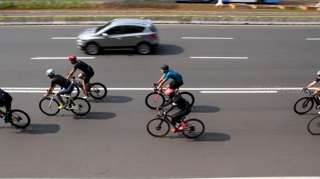 Warga berolahraga di Jalan Jenderal Sudirman, Jakarta, Minggu (9/6). [Suara.com/Arief Hermawan P]