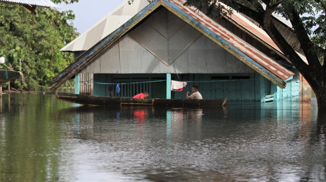 Warga berada di atas perahu menerobos banjir sejak dua pekan lalu di Desa Laloika, Kecamatan Pondidaha, Konawe, Sulawesi Tenggara, Minggu (9/6). [ANTARA FOTO/Jojon]