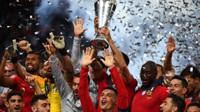 Kapten Timnas Portugal, Cristiano Ronaldo (tengah), merayakan keberhasilan negaranya menjuarai edisi pertama UEFA Nations League, Minggu (9/6/2019). [AFP/Gabriel Bouys]