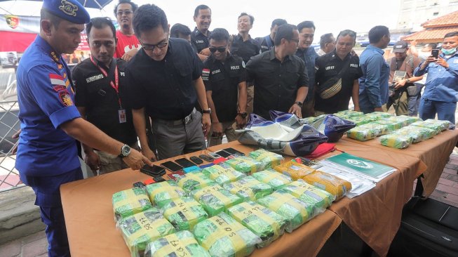 Kepala Biro Penerangan Masyarakat Divisi Humas Polri Brigjen Pol Dedi Prasetyo beserta jajaran memperlihatkan tersangka dan barang bukti saat rilis penyelundupan narkotika jenis shabu sindikat kejahatan terorganisir Malaysia-Jakarta menggunakan kapal pesiar di Marina Batavia, Pelabuhan Sunda Kelapa, Jakarta, Selasa (11/6). [Suara.com/Muhaimin A Untung]