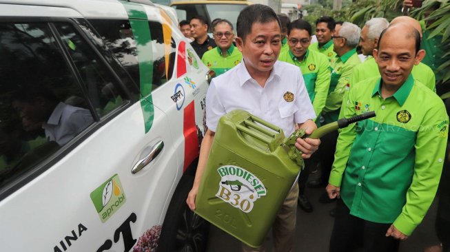 Menteri ESDM Ignasius Jonan didampingi Wakil Menteri ESDM Arcandra Tahar menuang bahan bakar Biodisel 30 saat launching road test penggunaan B30 di gedung KESDM, Jakarta, Kamis (13/6). [Suara.com/Muhaimin A Untung]