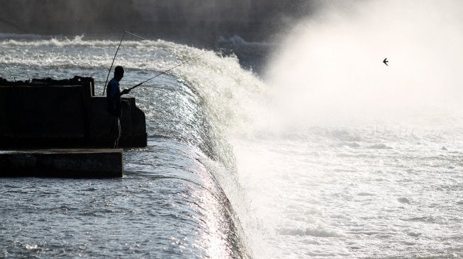 Warga memancing di Bendungan Karet atau Dam Karet (Rubber Dam), Kecamatan Megaluh, Kabupaten Jombang, Jawa Timur, Kamis (13/6). [Suara.com/Arief Hermawan P]