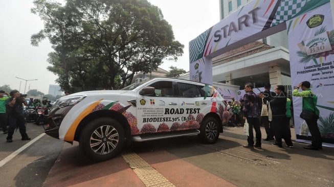 Petugas membawa mobil dengan menggunakan bahan bakar Biodisel 30 saat launching road test penggunaan B30 di gedung KESDM, Jakarta, Kamis (13/6). [Suara.com/Muhaimin A Untung] 