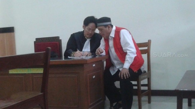 Caleg Partai Nasdem Mahmud saat menjalani sidang kasus penipuan tanah. (Suara.com/Tofan)