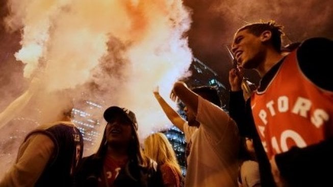 Para suporter Toronto Raptors di kota Toronto merayakan kemenangan timnya menjadi juara NBA 2019. Geoff Robins / AFP