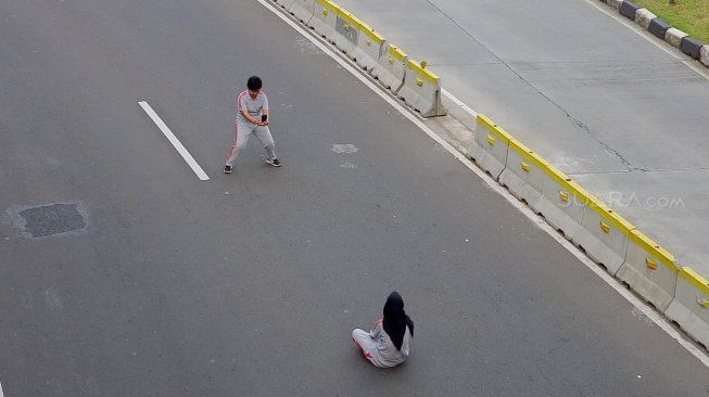 Warga berselfie di Jalan Merdeka Barat, Jakarta, Jumat (14/6). [Suara.com/Oke Atmaja]