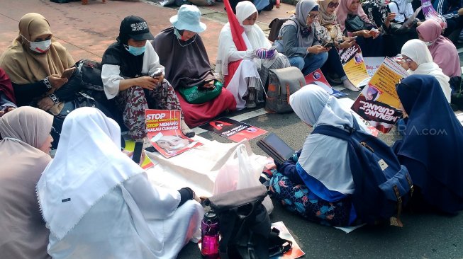 Sejumlah emak-emak membaca Alquran di sela sidang sengketa Pilpres yang digelar di Mahkamah Konstitusi, Jakarta, Jumat (14/6). [Suara.com/Oke Atmaja]