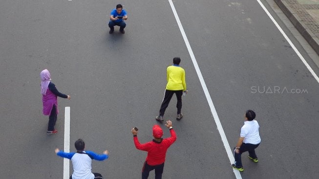 Warga berselfie di Jalan Merdeka Barat, Jakarta, Jumat (14/6). [Suara.com/Oke Atmaja]