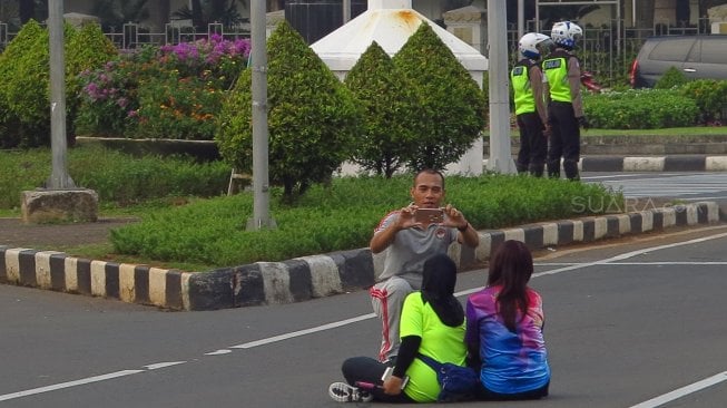 Warga berselfie di Jalan Merdeka Barat, Jakarta, Jumat (14/6). [Suara.com/Oke Atmaja]