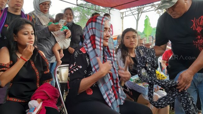 Istri mendiang Robby Sugara di pemakaman sang suami di TPU Pondok Ranggon, Jakarta Timur, Jumat (14/6/2019). [Revi C Rantung/Suara.com]