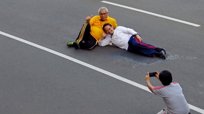 Warga berselfie di Jalan Merdeka Barat, Jakarta, Jumat (14/6). [Suara.com/Oke Atmaja]