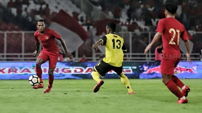 Pesepak bola timnas Indonesia Yustinus Paew dengan pesepak bola timnas Vanuatu pada pertandingan persahabatan di Stadion Gelora Bung Karno, Jakarta, Sabtu (15/6). [Suara.com/Muhaimin A Untung]