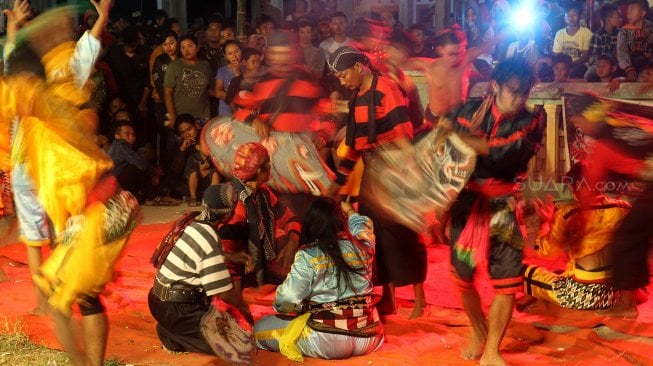 Warga menyaksikan Kesenian Jaranan di Dusun Paras, Desa Turipinggir, Kecamatan Megaluh, Kabupaten Jombang, Jumat (14/6). [Suara.com/Arief Hermawan P]