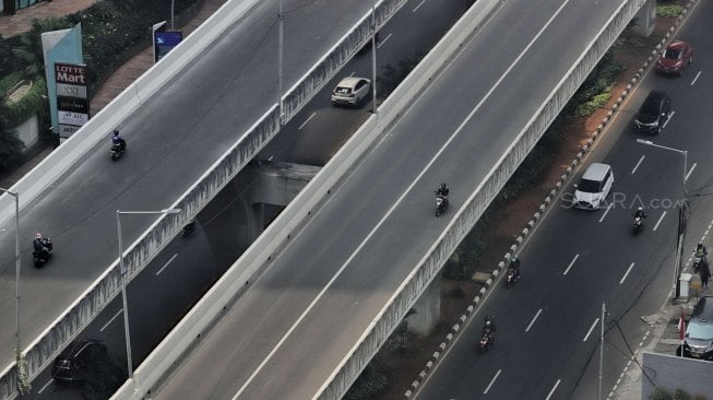 Sejumlah pengendara sepeda motor melintasi Jalan Layang Non Tol (JLNT) Kampung Melayu-Tanah Abang di kawasan Casablanca, Jakarta, Sabtu (15/6). [Suara.com/Muhaimin A Untung]