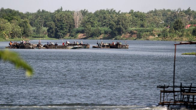 Sejumlah warga berada di atas perahu saat menambang pasir di Sungai Brantas, Kecamatan Megaluh, Kabupaten Jombang, Jawa Timur, Minggu (16/6). [Suara.com/Arief Hermawan P]