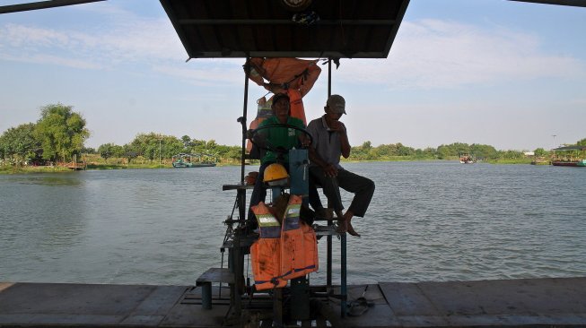 Sejumlah warga menyeberangi Sungai Brantas menggunakan jasa perahu tambang di kawasan Megaluh, Kabupaten Jombang, Jawa Timur, Minggu (16/6). [Suara.com/Arief Hermawan P]