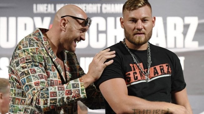 Petinju kelas berat asal Inggris, Tyson Fury (kiri), dan Tom Schwarz usai konferensi pers di MGM Grand Garden Arena, Las Vegas, AS, Rabu (12/6/2019). [AFP/Ethan Miller]