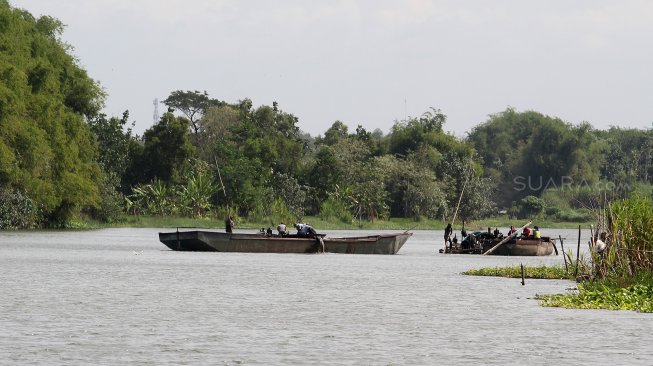 Sejumlah warga berada di atas perahu saat menambang pasir di Sungai Brantas, Kecamatan Megaluh, Kabupaten Jombang, Jawa Timur, Minggu (16/6). [Suara.com/Arief Hermawan P]