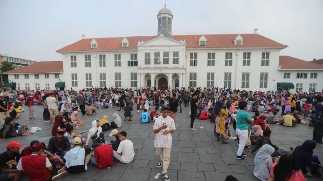 Sejumlah wisatawan menikmati suasana Museum Fatahillah di kawasan Kota Tua Jakarta, Minggu (16/6). [Suara.com/Muhaimin A Untung]