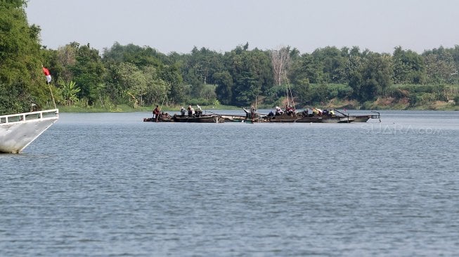 Sejumlah warga berada di atas perahu saat menambang pasir di Sungai Brantas, Kecamatan Megaluh, Kabupaten Jombang, Jawa Timur, Minggu (16/6). [Suara.com/Arief Hermawan P]