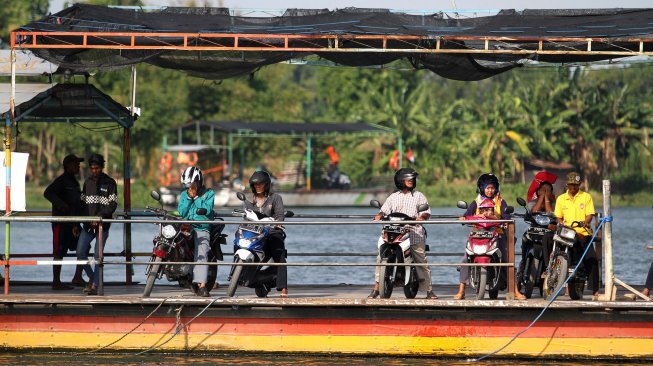 Sejumlah warga menyeberangi Sungai Brantas menggunakan jasa perahu tambang di kawasan Megaluh, Kabupaten Jombang, Jawa Timur, Minggu (16/6). [Suara.com/Arief Hermawan P]