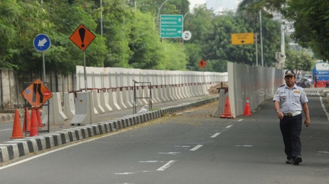 Sejumlah pekerja beraktifitas di samping proyek kereta Light Rail Transit (LRT) di Jalan Setiabudi Tengah, Jakarta Pusat, Senin (17/6). [Suara.com/Muhaimin A Untung]