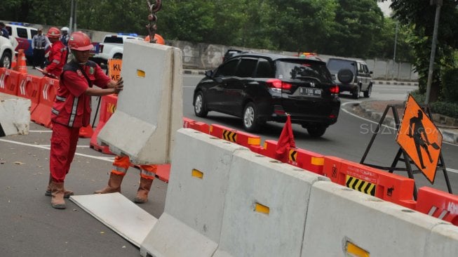 Sejumlah pekerja beraktifitas di samping proyek kereta Light Rail Transit (LRT) di Jalan Setiabudi Tengah, Jakarta Pusat, Senin (17/6). [Suara.com/Muhaimin A Untung]