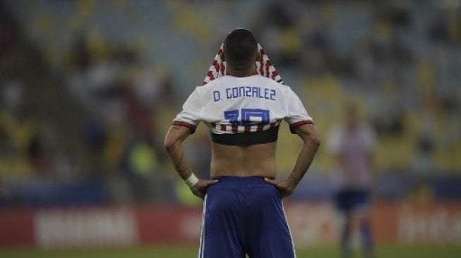 Pemain Paraguay Derlis Gonzalez menutup wajhnya setelah timnya ditahan imbang Qatar di Copa America 2019. Carl DE SOUZA / AFP