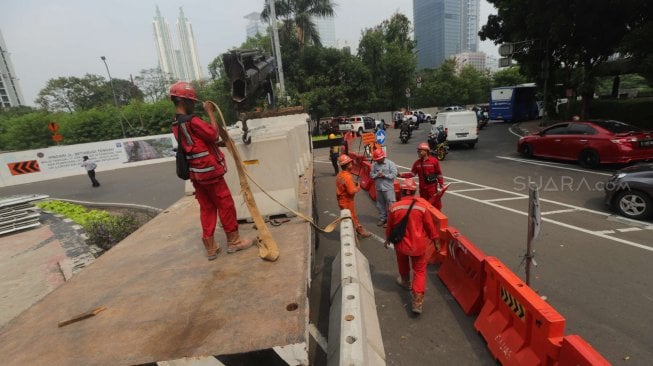 Sejumlah pekerja beraktifitas di samping proyek kereta Light Rail Transit (LRT) di Jalan Setiabudi Tengah, Jakarta Pusat, Senin (17/6). [Suara.com/Muhaimin A Untung]