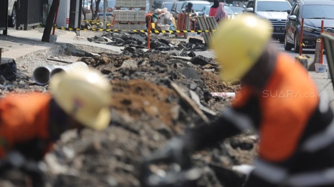 Pekerja menyelesaikan penataan Trotoar Cikini dan Kramat di kawasan Cikini, Jakarta Pusat, Rabu (19/6). [Suara.com/Muhaimin A Untung]