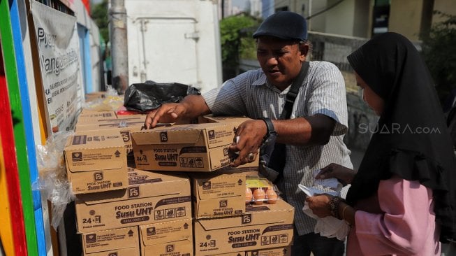 Warga berbelanja kebutuhan pokok saat kegiatan program pangan murah di Ruang Terpadu Ramah Anak (RPTRA) Saharjo Mentas, Jakarta, Kamis (20/6). [Suara.com/Muhaimin A Untung]