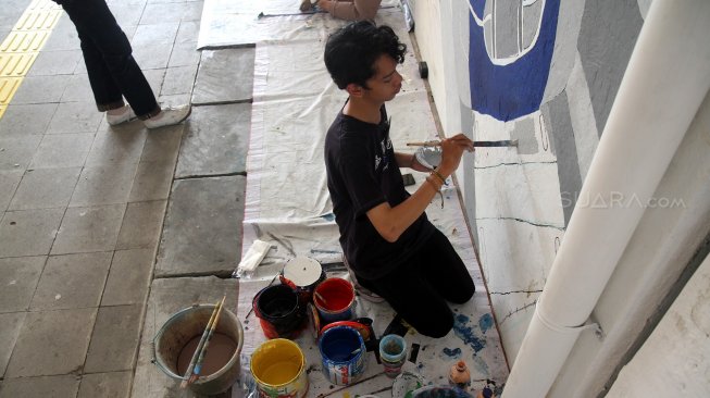 Sejumlah mahasiswa menyelesaikan pembuatan mural di terowongan Kendal, Dukuh Atas, Jakarta, Kamis (20/6). [Suara.com/Arief Hermawan P]