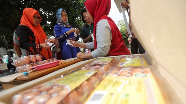 Warga berbelanja kebutuhan pokok saat kegiatan program pangan murah di Ruang Terpadu Ramah Anak (RPTRA) Saharjo Mentas, Jakarta, Kamis (20/6). [Suara.com/Muhaimin A Untung]