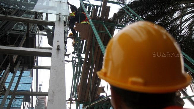 Pekerja menyelesaikan pembongkaran lift Jembatan Penyeberangan Orang (JPO) Tosari di kawasan Bundaran HI, Jakarta, Rabu (19/6). [Suara.com/Arief Hermawan P]