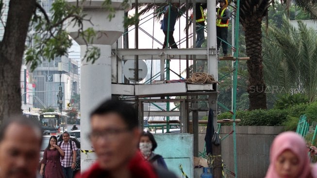 Pekerja menyelesaikan pembongkaran lift Jembatan Penyeberangan Orang (JPO) Tosari di kawasan Bundaran HI, Jakarta, Rabu (19/6). [Suara.com/Arief Hermawan P]