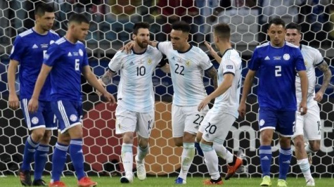 Kapten Argentina Lionel Messi (kiri) merayakan gol ke gawang Paraguay dari titik penalti bersama rekan setimnya Lautaro Martinez (tengah) dan Giovani Lo Celso di Copa America 2019. Douglas Magno / AFP